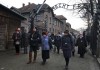 Những cựu tù nhân sống sót qua đại nạn holocaust đi qua cổng của trại chính Auschwitz với hàng chữ khét tiếng “Lao động giải phóng con người” (Arbeit macht frei) - Ảnh: Czarek Sokolowski (MTI)