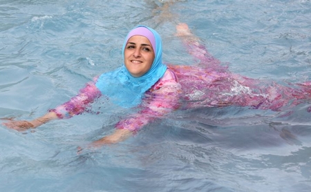 Một phụ nữ trẻ người Thổ mặc burkini tại một bể tắm ngoài trời. Có nên cấm? - Ảnh: politico.eu