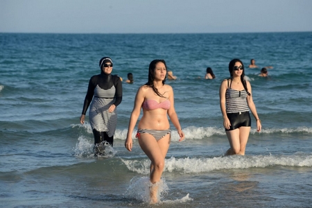 Phụ nữ với trang phục bikini và burkini ở bãi biển Tunesia - Ảnh: thestar.com