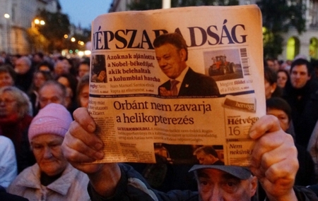 Người biểu tình phản đối việc đóng cửa “Tự do Nhân dân”, giơ cao số báo cuối cùng - Ảnh: wPolityce.pl