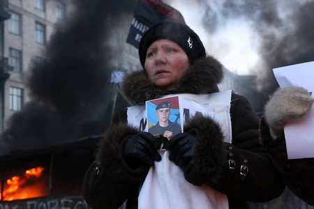 Một phụ nữ cầm trong tay bức ảnh Mikhail Zhiznevsky, 25 tuổi, một trong ba người biểu tình chống chính phủ đã bị thiệt mạng trong đụng độ với cảnh sát chống bạo động gần Quảng trường Độc Lập của Kiev (Maidan), ngày 25-1-2014 - Ảnh: Mai Kỳ