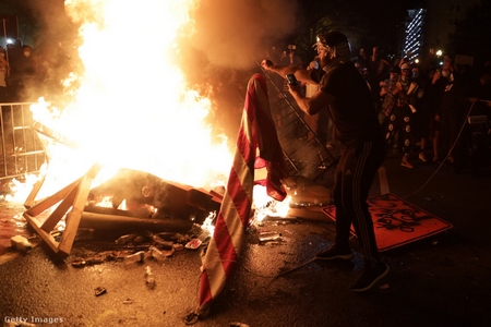 Một người biểu tình ném quốc kỳ Mỹ vào lửa tại khu vực gần tòa Bạch Ốc, ngày 31-5-2020 - Ảnh: Alex Wong