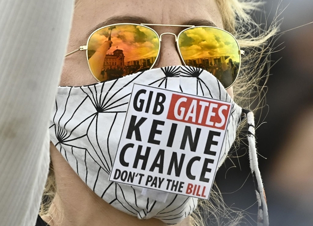 “Đừng cho Gates cơ hội!”, theo một tín đồ của “thuyết âm mưu” - Ảnh: Tobias Schwarz (AFP)