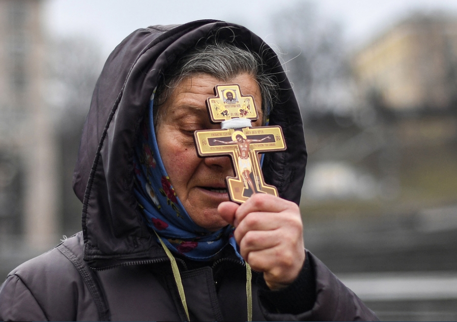 Một phụ nữ Ukraine cầu nguyện tại Kiev, ngày 24/2/2022 - Ảnh: Daniel Leal (AFP)