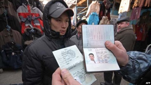 Cảnh sát Nga kiểm tra hộ chiếu và thị thực của một người Việt tại một khu chợ thuộc miền Viễn Đông nước Nga - Ảnh: RIA Novosti/ AFP